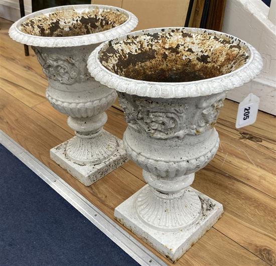 A pair of white painted cast iron campana-shaped urns, height 37cm